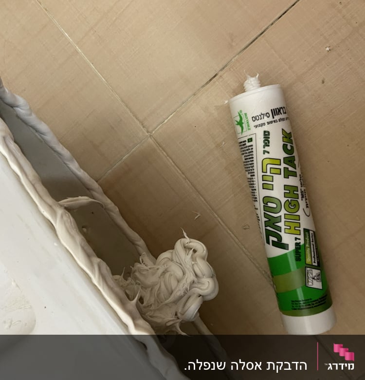 שפופרת דבק סיליקון ליד כיור עם איטום